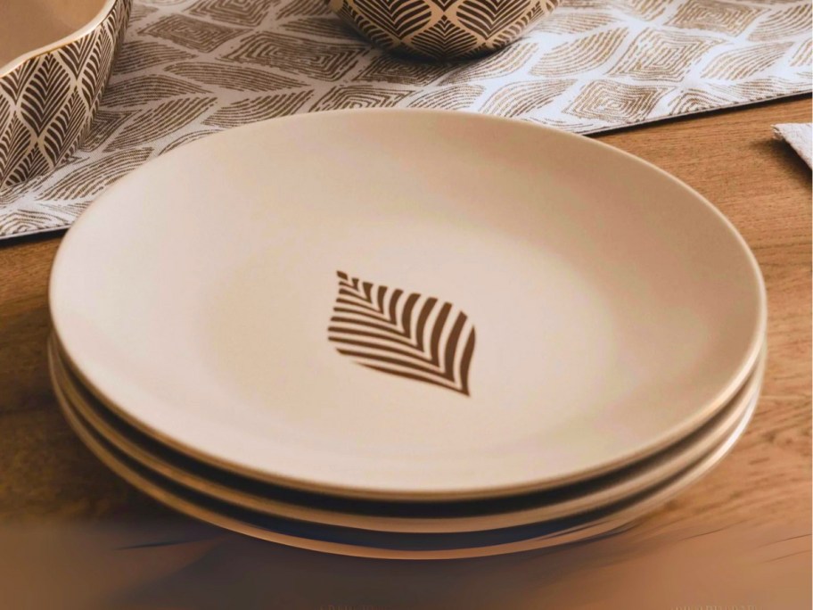 a set of dinnerware plates with a single leaf pattern on a table
