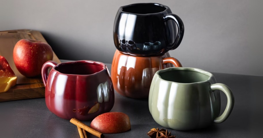 a set of 4 pumpkin shaped coffee mugs in different colors