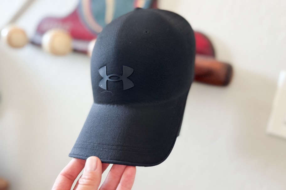 hand grabbing black hat off hook