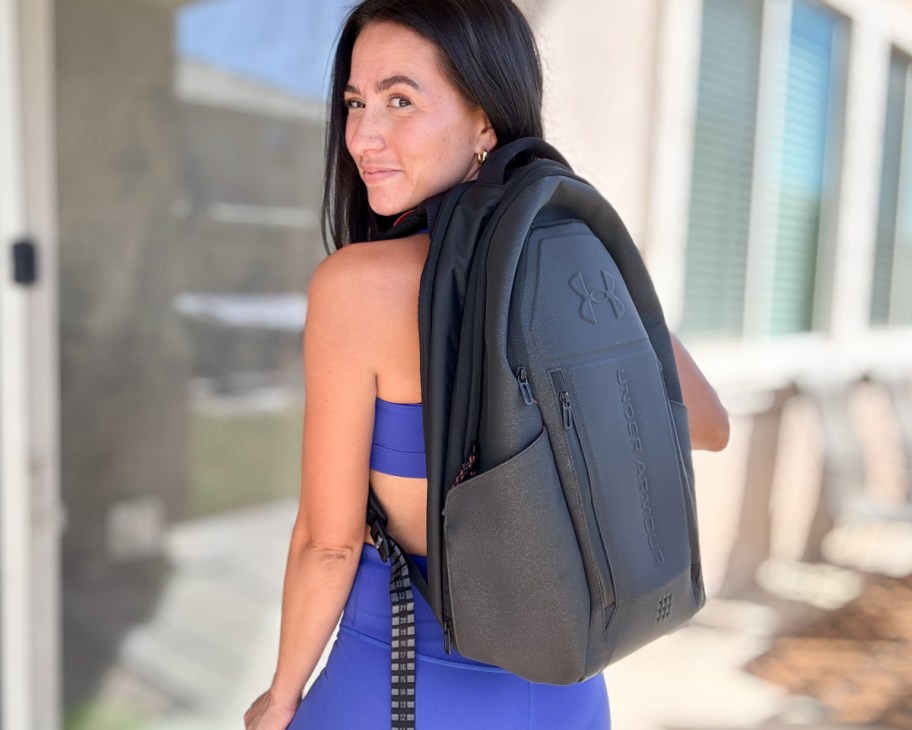 woman in blue workout outfit with black backpack on