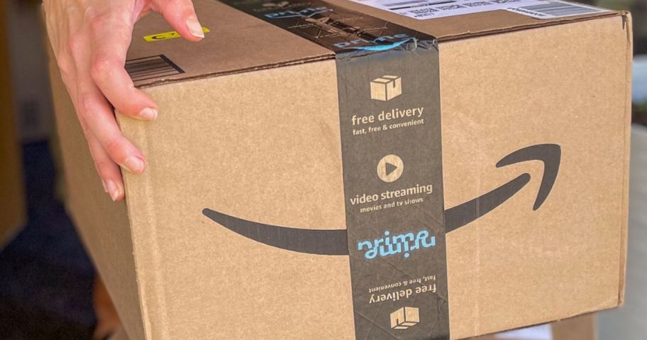 Hand picking up an Amazon Box