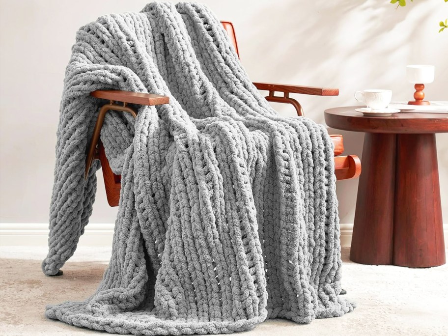 grey chunky knit throw blanket draped over an accent chair