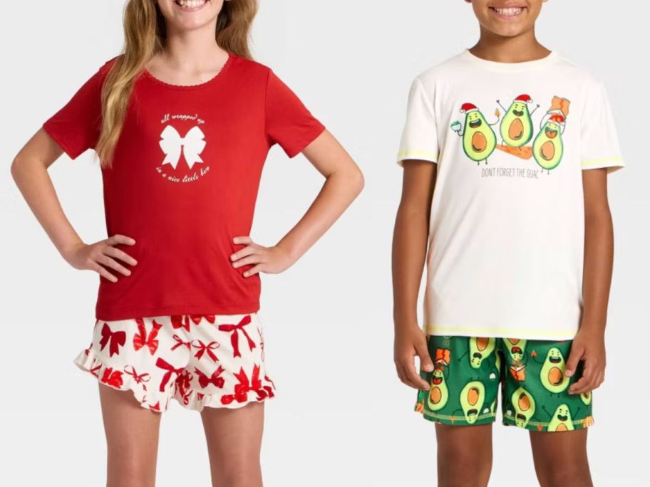 2 kids wearing green, white, and red Christmas pajamas