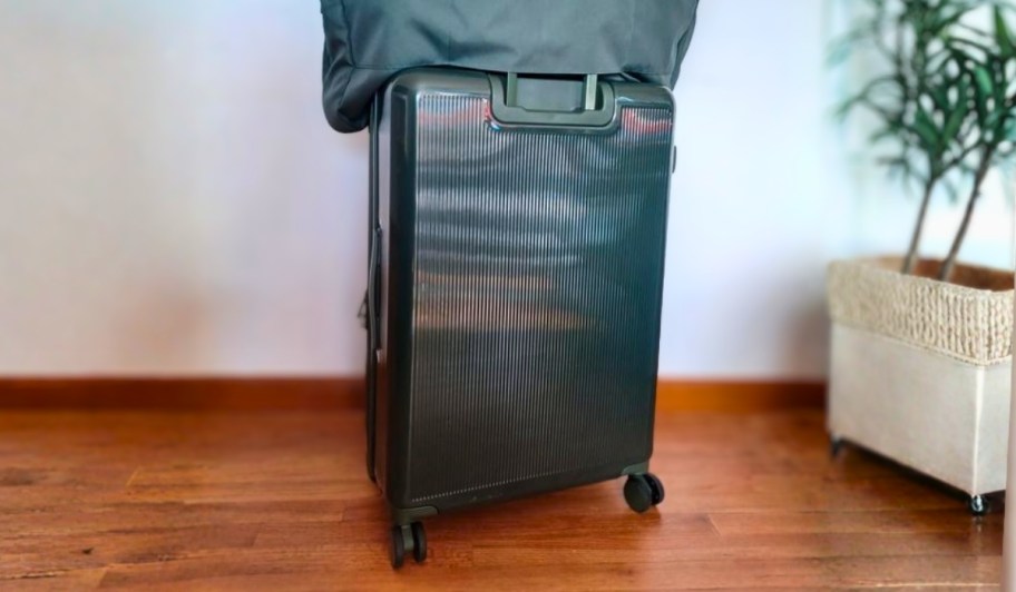 home edit green hardside suitcase with weekender bag resting on top
