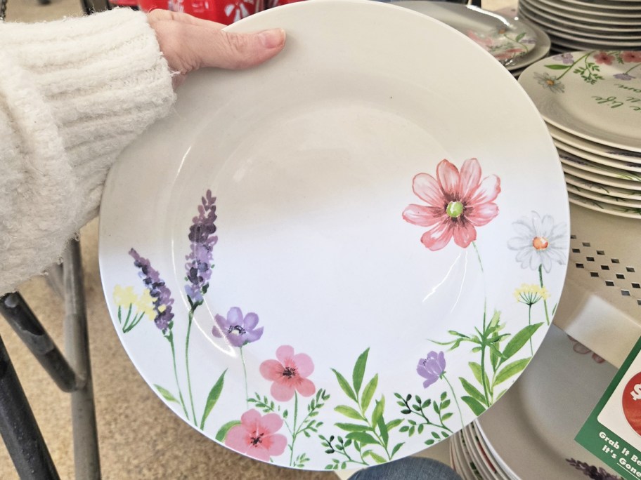 hand holding up a floral print plate in store