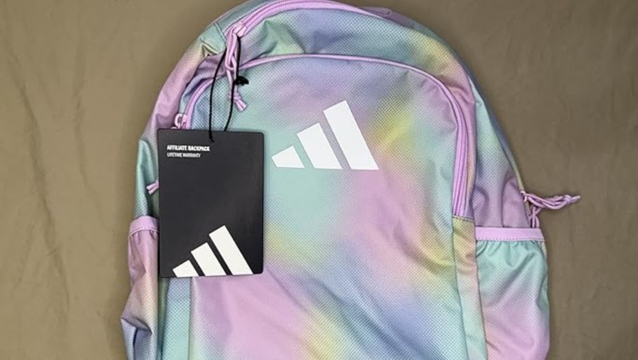 pastel rainbow adidas backpack with bladk tag on it