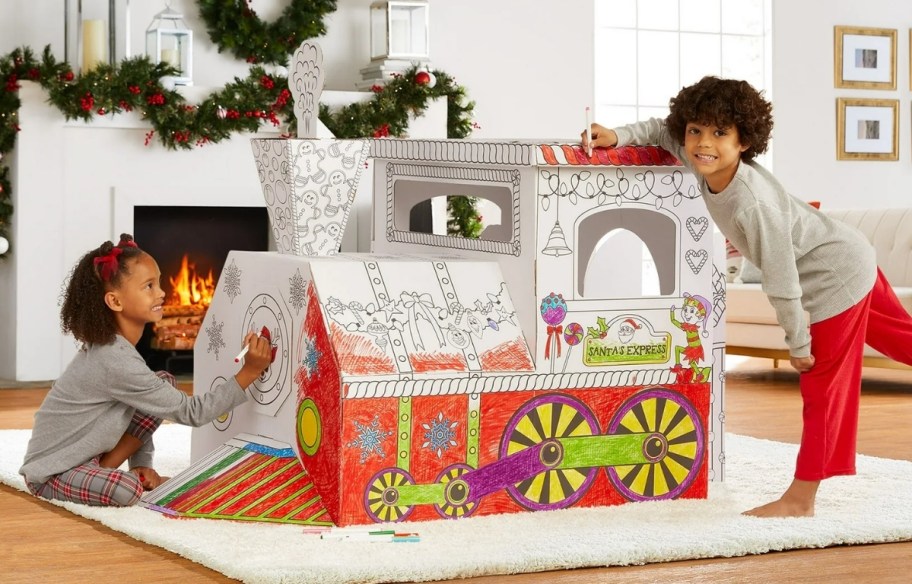 two kids coloring a cardboard train