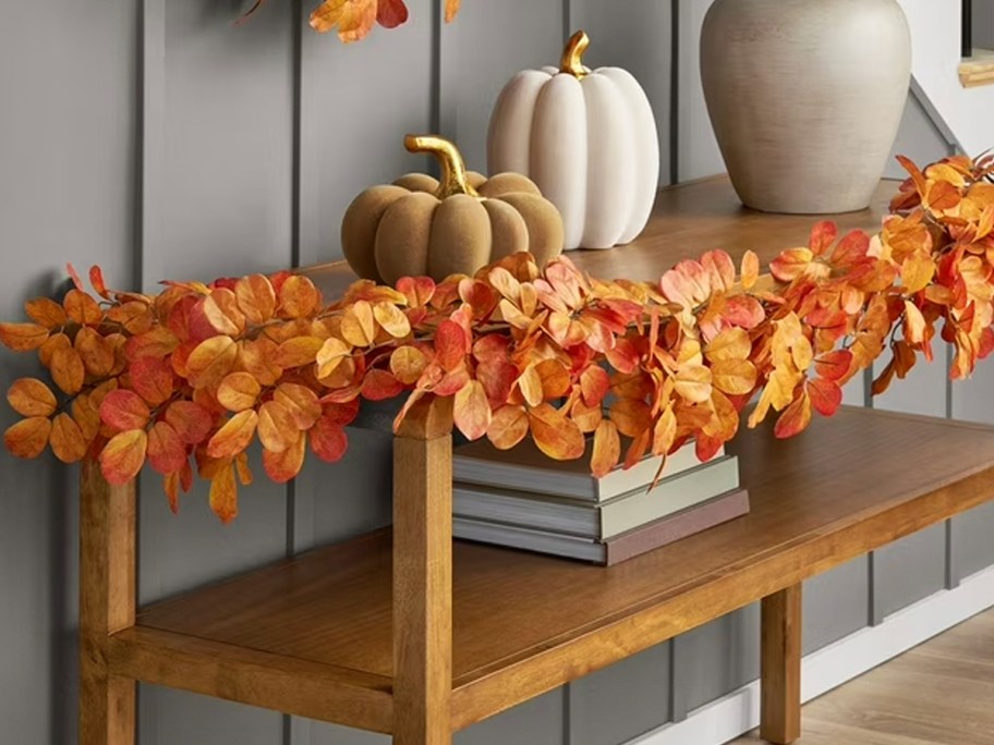 orange leaf garland on table with pumpkins 