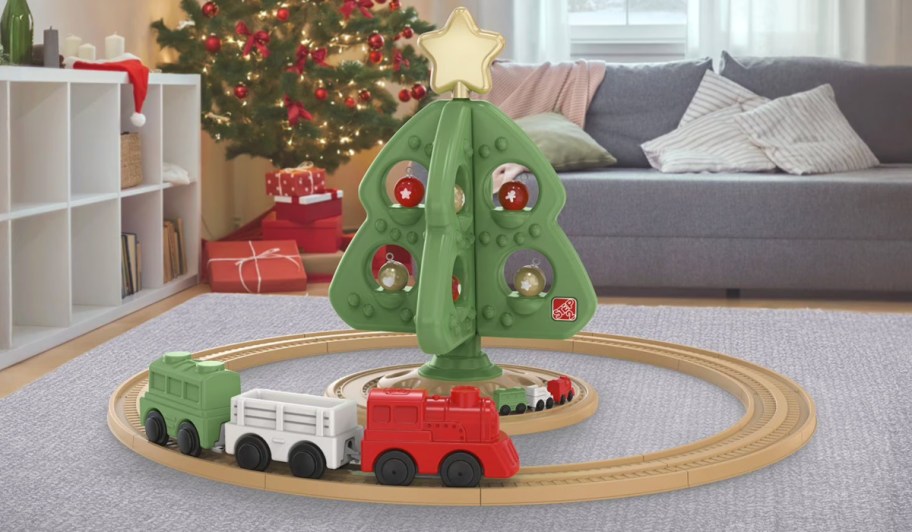 kids plastic christmas tree with toy train around it