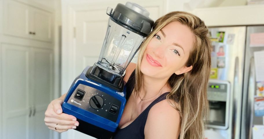 woman holding blue vitamix blender