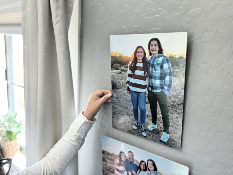 woman placing a walgreens metal photo panel on a wall