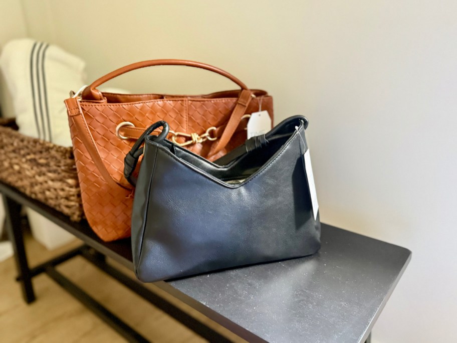 two purses next to each other on a bench