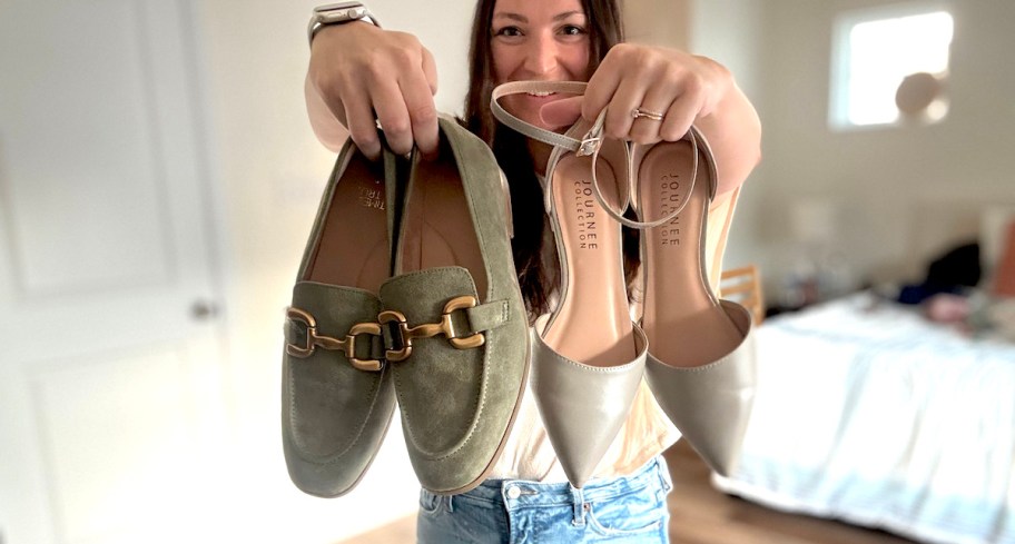 woman holding up a pair of green suede loafers and beige pointed heels