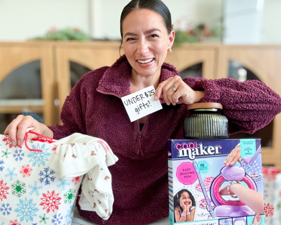 woman holding under $25 gifts notecard and holding various gifts