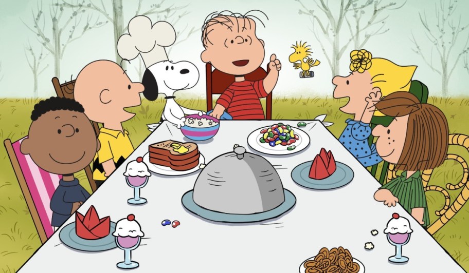 Charlie Brown Thanksgiving movie screen grab of character sitting around a table of food.