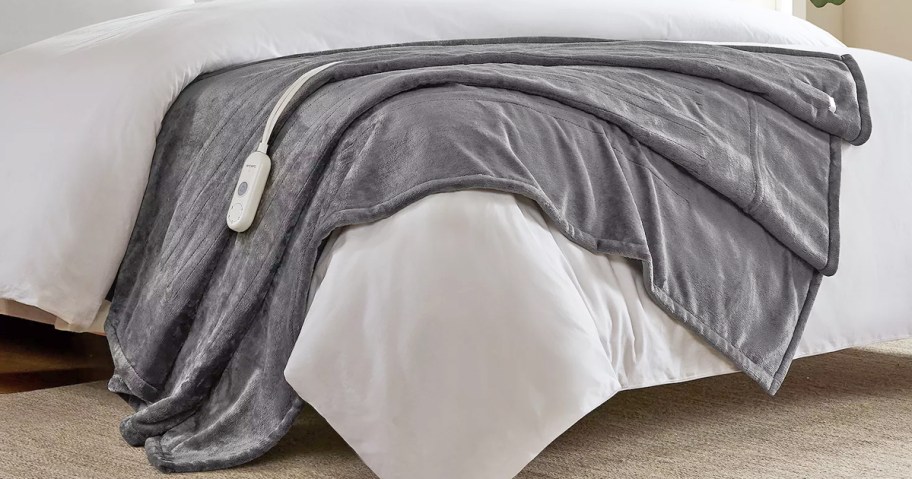 grey heated blanket draped over bed