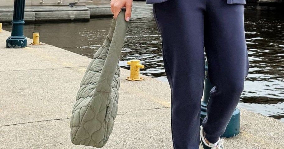 woman holding green quilted hobo shoulder bag outside