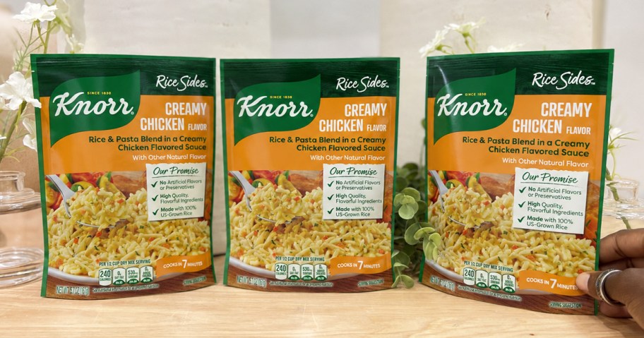 3 packs of Knorr Creamy Chicken Rice Sides on a wood table