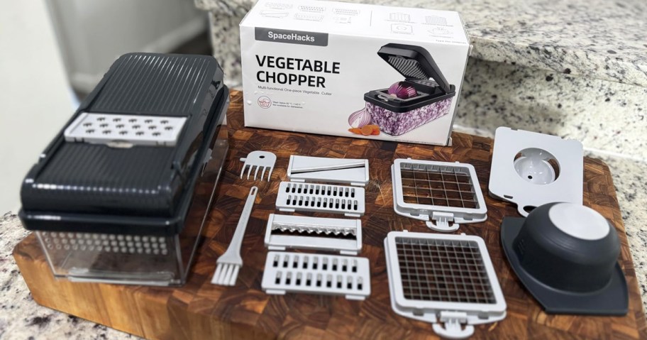 vegetable chopper, blades, and accessories on a cutting board