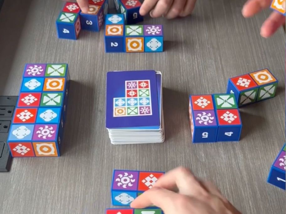 hands touching cards with symbols on them 