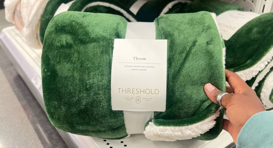 hand holding green blanket at the store