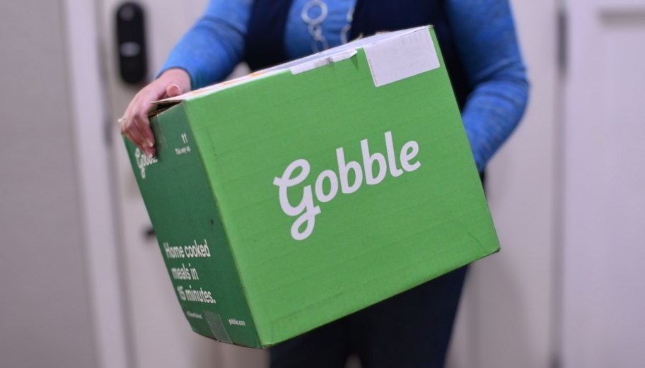 a woman carrying a green box