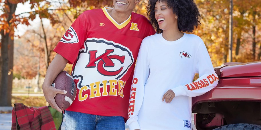 man wearing red chiefs jersey and woman wearing white long sleeve tee 