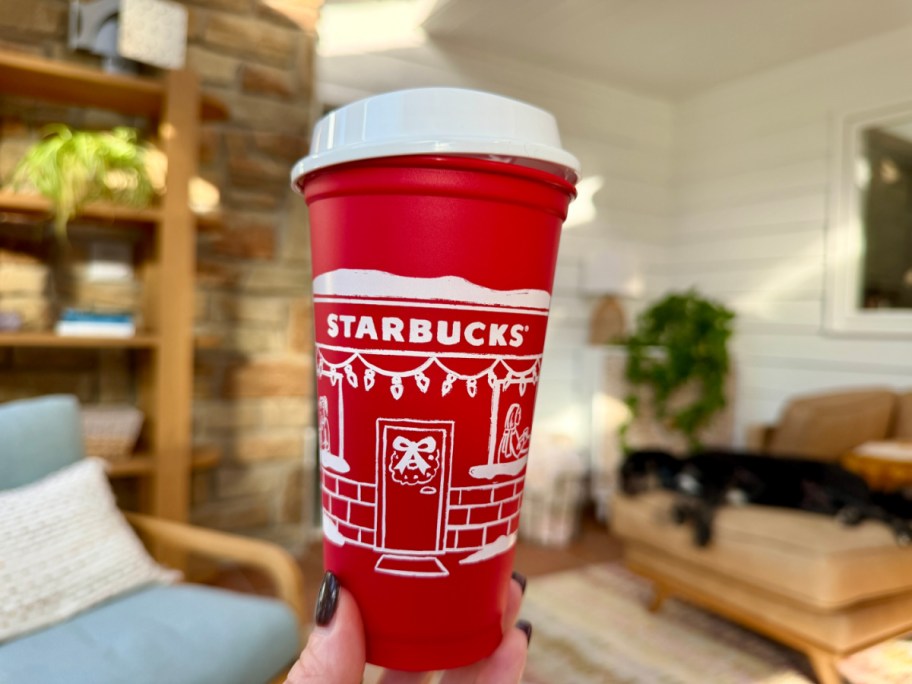 hand holding up a red Starbucks holiday cup