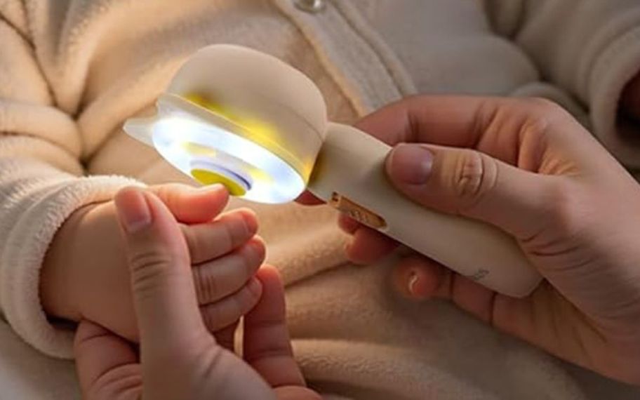 hand holding baby nail trimmer with light on it