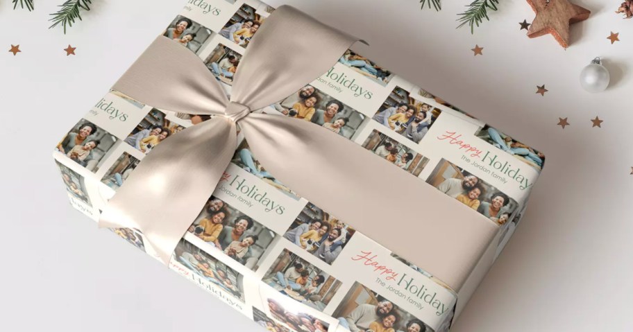 Box wrapped in custom happy holidays, wrapping paper with silver bow