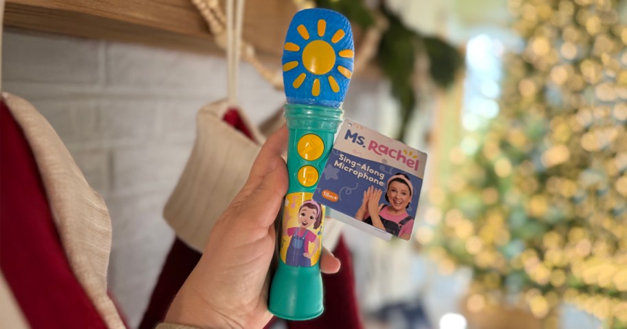 Ms Rachel Sing Along Microphone in front of stockings and Christmas Tree