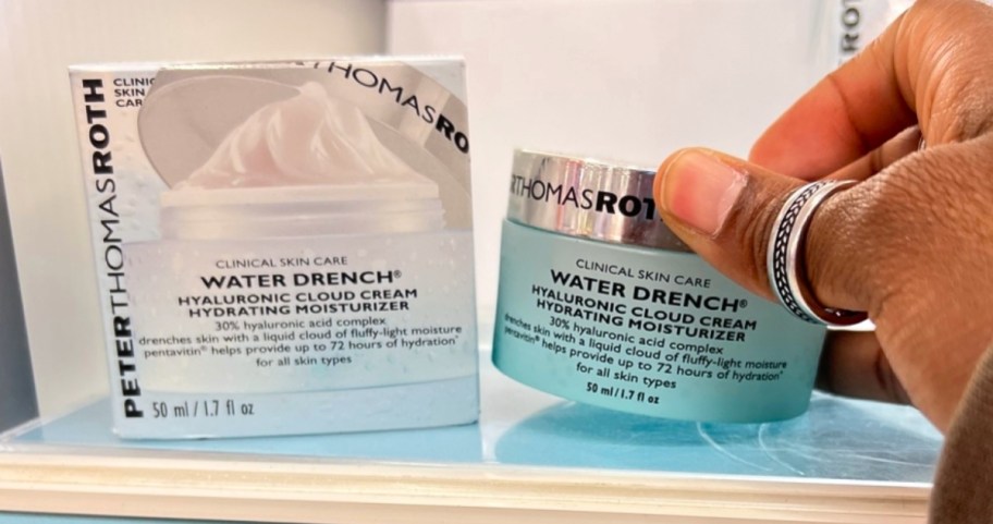 woman reaching for a jar of moisturizer on a store shelf