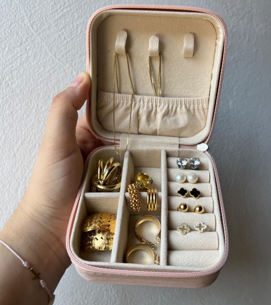 hand holding pink Travel Jewelry Case with gold jewelry 