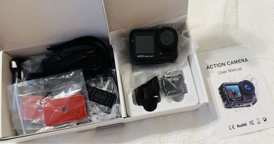 A camera in a box with multiple attachments and accessories around it 