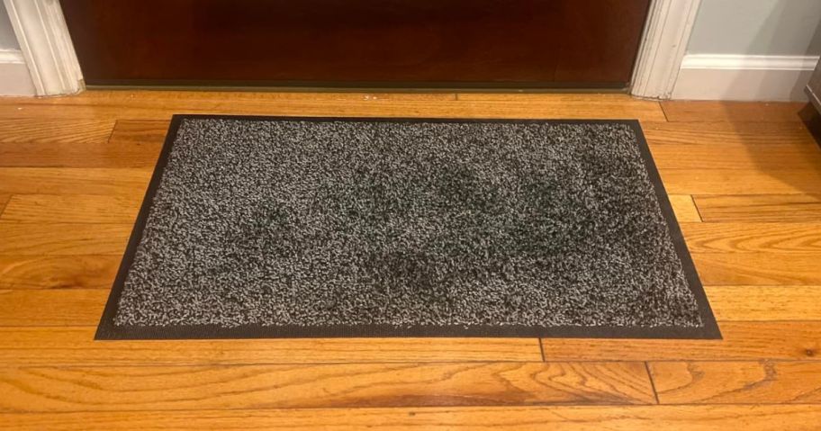 black doormat in front of door in entryway