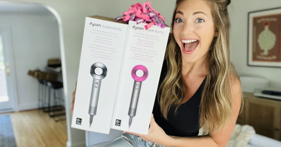 woman holding two Dyson Supersonic Nural Hair Dryer boxes
