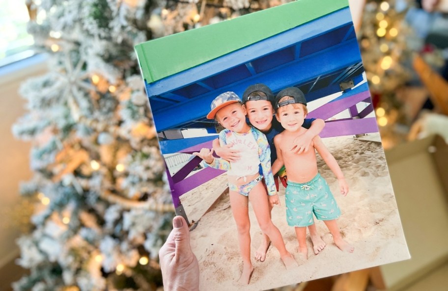 a womans hand holding a photo canvas