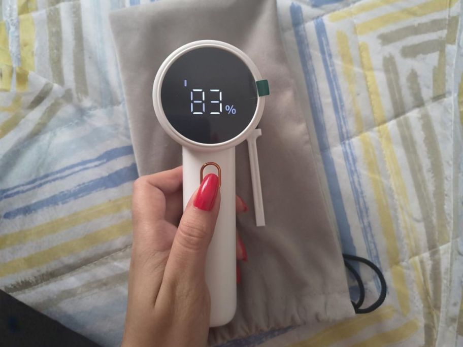 hand holding white fabric shaver