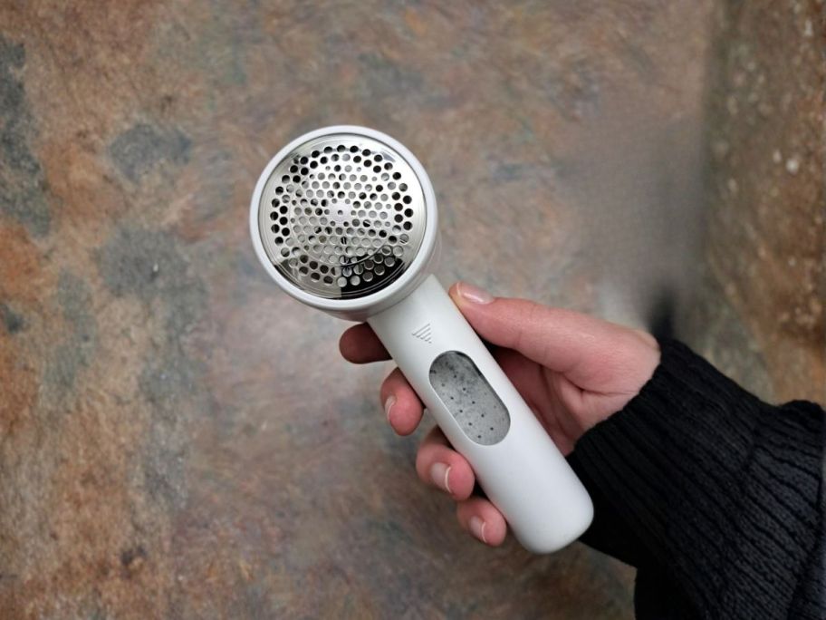 hand holding white fabric shaver