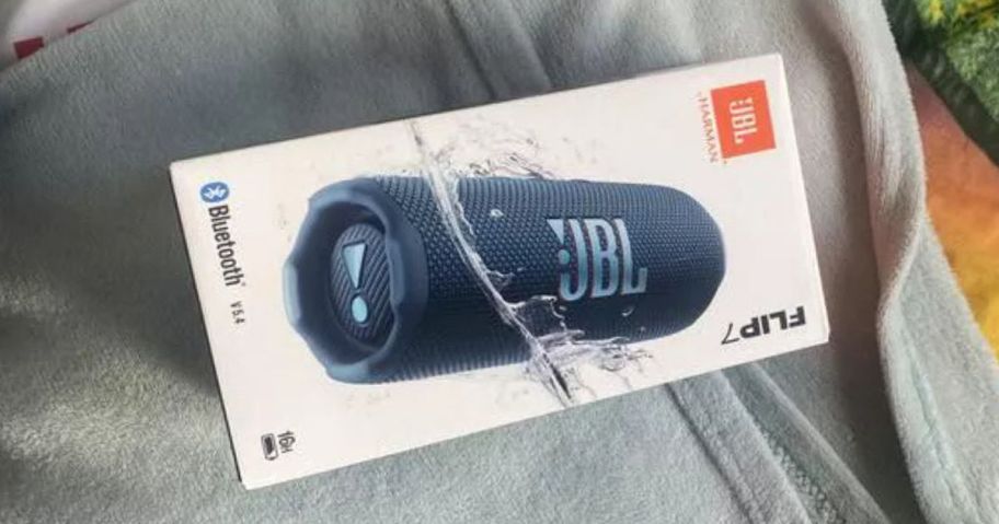 blue jbl speaker box on blanket