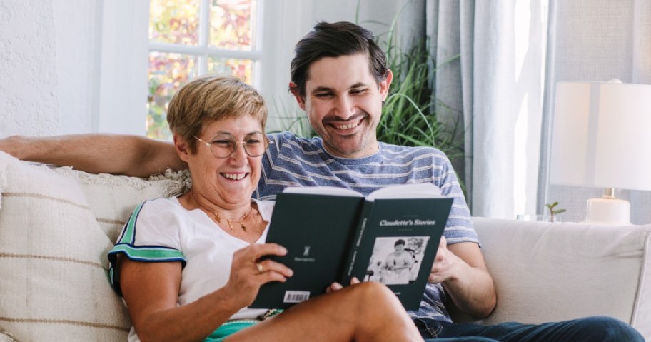 man and woman on a couch looking at a book
