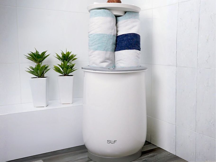towel warmer with towels in it in bathroom