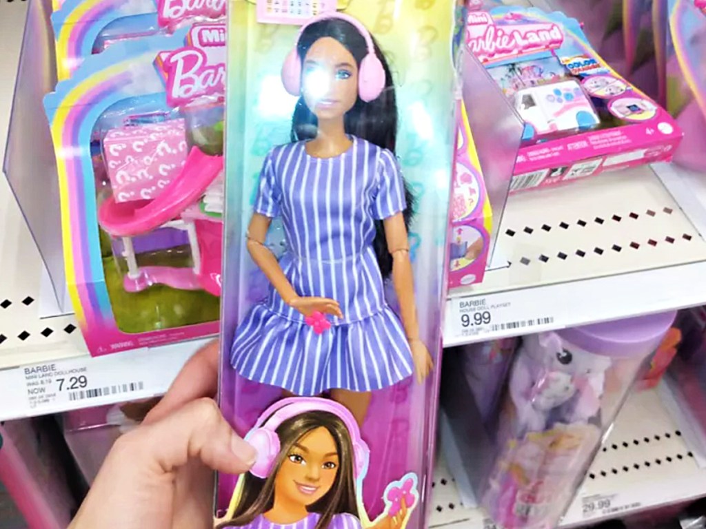 Person holding up autism Barbie inside target store