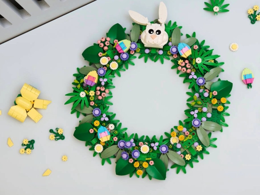 a LEGO Spring Wreath laying on a table with additional LEGO pieces around it