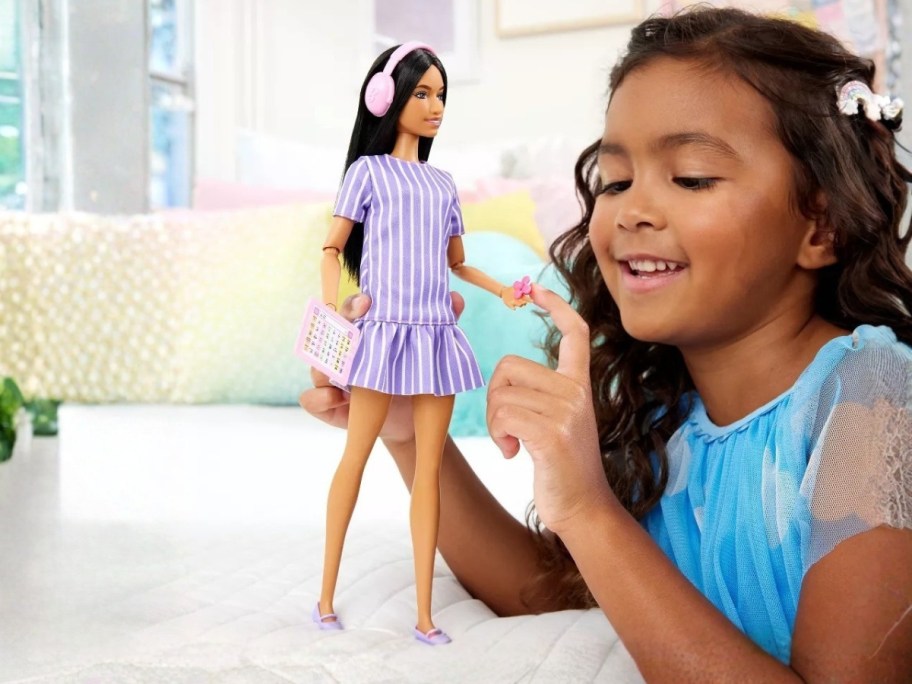 little girl playing an Autistic Barbie Fashionista Doll and accessories