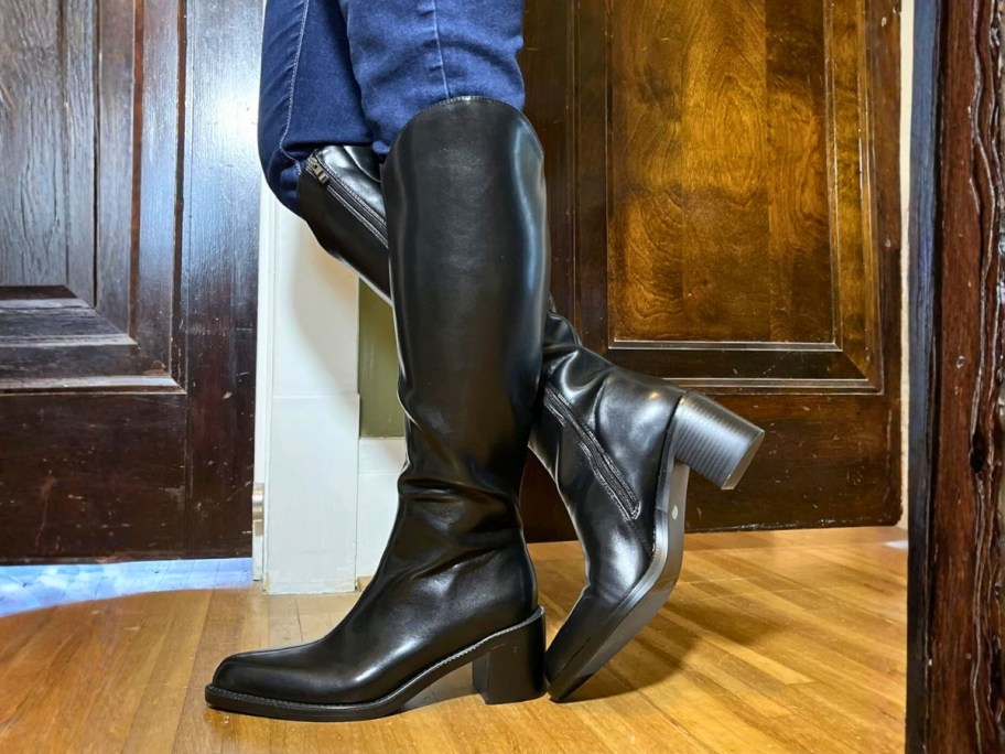 woman's legs wearing black knee high boots