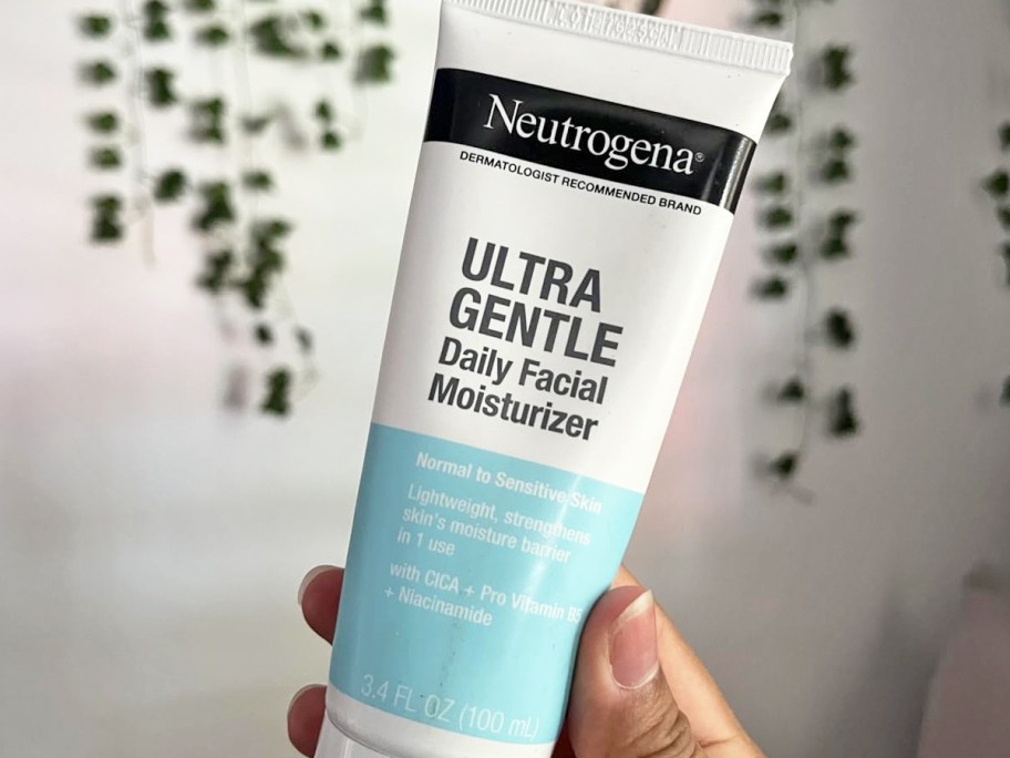 hand holding a white tube of Neutrogena&nbsp;Facial Moisturizer
