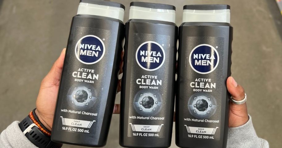 Hand holding 3 bottles of Nivea Men's Charcoal Body Wash