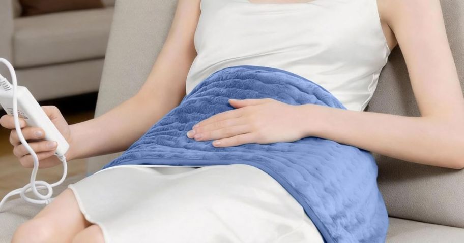woman using heating on lap with remote while layign down