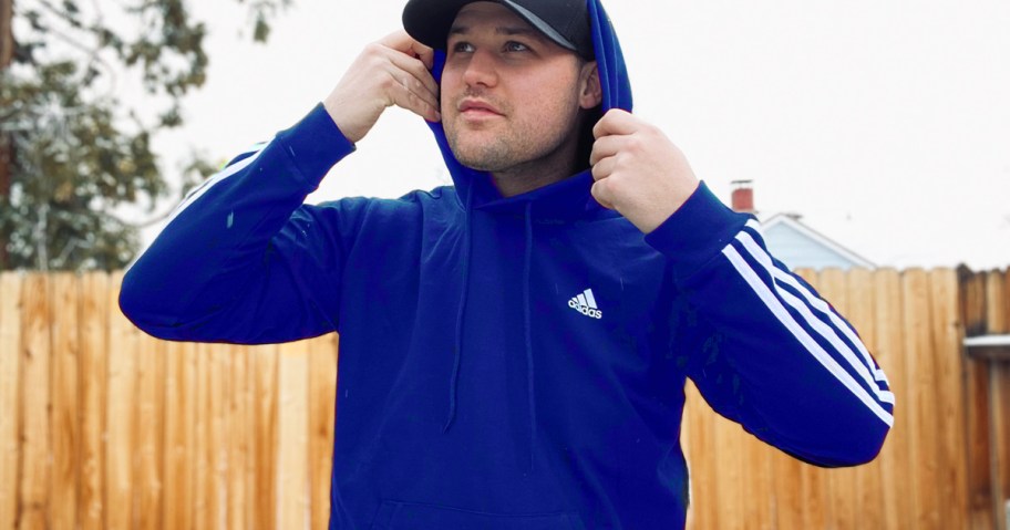 man standing outside in a blue adidas hoodie